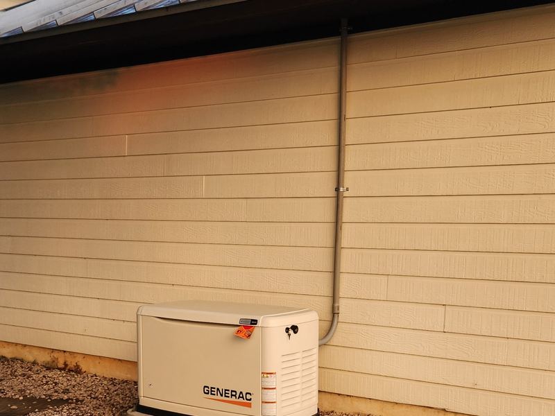 Generac generator installed beside home siding