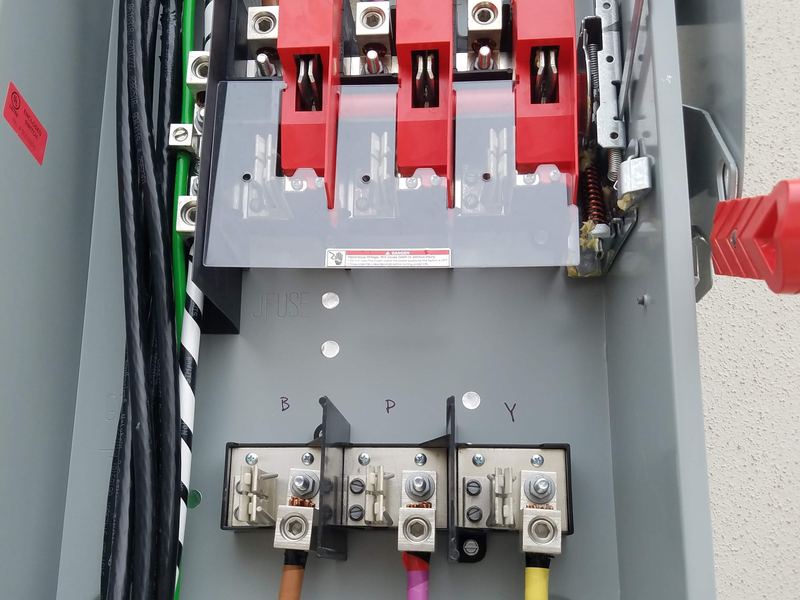 Close-up of electrical panel wiring with color-coded conductors